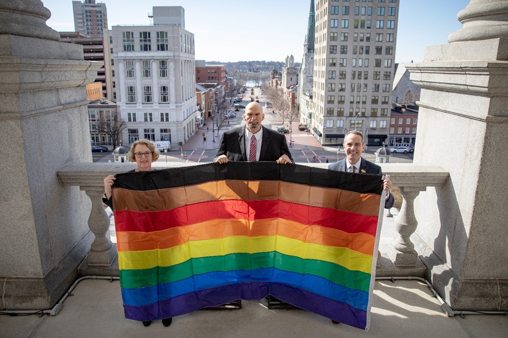 5 de febrero de 2020: La senadora Santarsiero, con la diputada Wendy Ullman y el vicegobernador John Fetterman, enarbolando la bandera LGBTQ+ en el balcón del edificio del capitolio.
